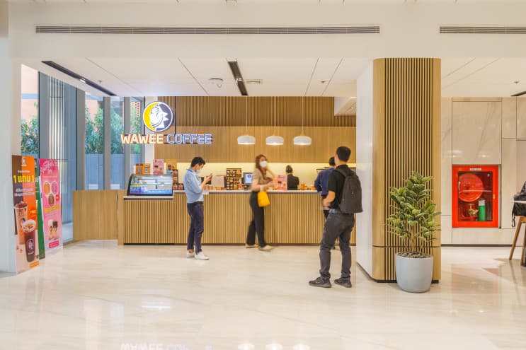 ทัวร์ BJC Big C ออฟฟิศในฝัน สร้างสรรค์ชีวิตที่ดีกว่าเพื่อทุกคน - ไม่แปลกใจ ว่าทำไมที่นี่ถึงเป็นที่ทำงานในฝันของใครหลายๆ คน เพราะแค่เดินเข้ามาที่ล็อบบี้ออฟฟิศของ BJC ก็ต้องว้าวกับดีไซน์ที่ดูทันสมัยและเรียบหรูมากๆ เป็นพื้นที่โซนแรกที่สร้างความประทับใจให้พนักงานและแขกผู้มาเยือนได้ไม่น้อย ถือเป็นการสร้างบรรยากาศก่อนการเริ่มงานได้ดีเลยทีเดียว
2. ห้องประชุมมากมาย
เรียกได้ว่าที่นี่มีห้องประชุมครบทุกแบบ ทุกขนาดที่พนักงานต้องการเลยทีเดียว จะประชุมเล็ก 2-5 คน หรือประชุมใหญ่ทั้งแผนกก็มีห้องไว้รองรับแบบไร้กังวล แถมเทคโนโลยีอำนวยความสะดวกอย่าง Projector, LCD Projector และ TV ก็มีไว้ให้พร้อม เป็นไงล่ะ…ครบครันไปหมด
3. โซนล็อคเกอร์ประจำตัวสารพัดประโยชน์
ที่นี่มีล็อคเกอร์สำหรับพนักงานแต่ละคนให้สามารถใช้เก็บของส่วนตัว ของมีค่า หรือเอกสารต่างๆ ได้ พนักงานจะได้ไม่ต้องวางไว้ที่โต๊ะตัวเองให้กินพื้นที่ ช่วยเพิ่มพื้นที่ในการทำงานมากขึ้น โต๊ะโล่งก็รู้สึกสบายตา สบายสมอง ล็อคเกอร์ทุกช่องมีกุญแจล็อคอย่างปลอดภัยทำให้เรามั่นใจได้ว่าของของเรานั้นเก็บอยู่อย่างดีแน่นอน
4. พื้นที่ทำงานส่วนกลาง ไว้แชร์ประสบการณ์ร่วมกัน
ส่วนกลางที่ตกแต่งด้วยโทนสีน้ำตาลดูอบอุ่นและทันสมัย เก้าอี้นั่งสบายสุดๆ เป็นพื้นที่ที่ทุกคนสามารถมาใช้ได้เลย ใครนั่งทำงานบนโต๊ะเบื่อๆ จะเปลี่ยนบรรยากาศมานั่งทำงานตรงนี้ก็ได้ เป็นพื้นที่สำหรับสร้างสรรค์ไอเดียใหม่ๆ ในการทำงาน หรือจะนั่งพักผ่อนกับเพื่อนร่วมงานยามว่างก็ดี
5. โซนทำงานโล่งสบาย ให้ฟีลผ่อนคลายเหมือนทำงานที่บ้าน
บริเวณโต๊ะทำงานหรือโซนออฟฟิศเป็นส่วนที่สำคัญที่สุด เพราะพนักงานต้องใช้เวลาในพื้นที่นี้เป็นส่วนใหญ่ ที่นี่จึงออกแบบโซนนี้ให้มีพื้นที่กว้างขวาง ดูโล่งสบายตา ไม่อึดอัด มีแสงสว่างมากพอต่อการทำงาน ช่วยทำให้พนักงานทุกคนมีสมาธิกับการทำงานได้อย่างเต็มที่
6. กองทัพร้านอร่อย ที่ทานบ่อยๆ ก็ไม่เบื่อ
แน่นอนว่าพอหนังท้องตึง ไอเดียก็บังเกิด ของอร่อยและถูกสุขลักษณะจึงเป็นเรื่องที่สำคัญมากๆ ไม่ว่าจะเป็นอาหารตามสั่ง ก๋วยเตี๋ยวรสเด็ด ของทานเล่น หรือเครื่องดื่ม ที่นี่ก็มีครบ ไม่ต้องเดินออกไปด้านนอกให้ร้อน สะดวกสบายและประหยัดเวลาด้วยนะ
7. โรงอาหารสไตล์คาเฟ่ เก๋ไก๋ไม่ซ้ำใคร
นอกจากอาหารจะอร่อยแล้ว โซนที่นั่งในโรงอาหารยังจัดแต่งให้เป็นสไตล์คาเฟ่ด้วย ช่วยให้พนักงานผ่อนคลายได้ดีมากๆ นอกจากนี้ภายในก็ยังมีที่นั่งไว้รองรับคนได้เยอะ ไม่ต้องกลัวว่าเวลาพักเราจะมาแย่งที่นั่งกับใครเขาไม่ทันเลยล่ะ ที่นั่งก็มีหลายแบบหลายมุมให้เลือก ทั้งโซฟา โต๊ะกลม หรือโต๊ะสูง จะมานั่งทานคนเดียวหรือทานกับเพื่อนร่วมงานก็สามารถเลือกนั่งได้ตามใจชอบ เป็นอีกหนึ่งพื้นที่กระชับความสัมพันธ์กับเพื่อนร่วมงานได้ดีเลยทีเดียว
8. เติมพลังการทำงานได้ทั้งวัน ที่ร้านกาแฟวาวี
คนรักกาแฟห้ามพลาด ที่ตึก Big C มีร้านกาแฟวาวี (WAWEE COFFEE) กาแฟ “พรีเมี่ยมออร์แกนิก” จากไร่วาวี ไว้ให้เติมเอนเนอจี้ได้ทั้งวันเลย และใครจะรู้ว่านี่เป็นอีกหนึ่งธุรกิจของกลุ่ม BJC Big C ทำให้พนักงานที่นี่ได้รับส่วนลดพิเศษ และโปรโมชั่นอยู่บ่อยๆ นอกจากจะได้ดื่มกาแฟดีๆ แล้วยังได้ช่วยเหลือเกษตรกรและรักษาสิ่งแวดล้อมไปพร้อมกันอีกด้วย
9. ประชุมเครียดใช่มั้ย? โกโก้ดัทช์สักแก้วช่วยได้
มาทางฝั่งของตึก BJC ก็ไม่น้อยหน้า มีร้านโกโก้ดัทช์ คาเฟ่ไว้บริการ สายหวานแต่เข้มต้องห้ามพลาด เพราะที่นี่นอกจากจะมีโกโก้แท้100% จากประเทศเนเธอร์แลนด์แล้ว ยังมีโดนัทไว้ให้ทางคู่กัน ฟินได้ทั้งวันที่ล็อบบี้ตึก BJC
10. อีกมุมของล็อบบี้ออฟฟิศ Big C ที่สวยทันสมัย
อีกหนึ่งไฮไลท์สำคัญของตึก Big C ก็คือบันไดเลื่อนตรงล็อบบี้นี่แหละ ที่ทำให้ตึกดูโมเดิร์นขึ้นมากๆ ภายในยังถูกออกแบบด้วยโทนสีขาวสลับไม้ให้ดูสะอาดและสบายตา แถมตรงประตูทางเข้ายังมีร้านกาแฟวาวีไว้ให้พนักงานได้เติมพลังยามเช้า สาย บ่ายเย็นเลย พนักงานออฟฟิศอย่างเราถ้าได้กาแฟซักแก้วก็คงมีแรงทำงานไปตลอดทั้งวันแล้ว….จริงไหม?
11. โซน แชท&แชร์ ไอเดียให้พุ่งปรี๊ด
Co-working space ที่ดูผ่อนคลายด้วยพรมสีเขียวอ่อน ตกแต่งด้วยต้นไม้ และแสงไฟนวลๆ เป็นอีกหนึ่งจุดที่ให้พนักงานได้มานั่งแชร์ไอเดียใหม่ๆ กับเพื่อนร่วมงาน หรือใครจะอยากจะยกโน๊ตบุ๊คมานั่งทำงานตรงนี้ก็ได้ เผื่อจะปิ๊งอะไรใหม่ๆ มาอวดเพื่อน
12. โฟกัสกับตัวเองสักพัก ที่มุมทำงานส่วนตัว
มุมโต๊ะนั่งที่มีวิวเป็นกระจกที่สามารถมองเห็นได้รอบด้าน เหมาะกับการนั่งคิดอะไรคนเดียว ให้ได้นั่งทบทวนการทำงาน และโฟกัสกับงานมากขึ้น ยิ่งได้จิบกาแฟไปด้วยสักถ้วยยิ่งดีไปใหญ่เลย ใครนั่งหน้าจอคอมนานๆ ย้ายมาพักสายตาที่มุมนี้ก็ดีไม่น้อย
13. วิวภายนอกสุดคูล เหมือนทำงานที่นิวยอร์ก
ถือเป็นออฟฟิศที่สวยทันสมัยแนวหน้าของออฟฟิศย่านสุขุมวิท ที่ต้องยอมรับว่าทั้งการออกแบบภายในและภายนอกนั้นถูกวางมาอย่างพิถีพิถันให้ออฟฟิศของ BJC Big C มีเอกลักษณ์ไม่ซ้ำใคร ตอบสนองความต้องการของเหล่าคนทำงาน ที่ได้ทำงานอย่างมีความสุข ในพื้นที่ที่สามารถปลดปล่อยศักยภาพได้อย่างเต็มที่ และ สิ่งอำนวยความสะดวกมากมาย ที่ไม่ใช่จะหาจากที่ไหนได้ง่ายๆ
ถึงแม้ว่า BJC Big C จะมีออฟฟิศแยกกัน แต่ก็ยังอยู่ในพื้นที่เดียวกัน เรียกได้ว่าแค่เดินเปิดประตูออกไปก็ได้เจอเพื่อนใหม่ ให้ได้มาแลกเปลี่ยนประสบการณ์ เพื่อให้เราได้เก่งขึ้นและเติบโตขึ้นในทุกวัน ในออฟฟิศที่พร้อมจะ "สร้างสรรค์ชีวิตที่ดีกว่าเพื่อทุกคน" แล้วคุณล่ะ...พร้อมที่จะเข้ามาเป็นส่วนหนึ่งของที่นี่แล้วรึยัง? (7)